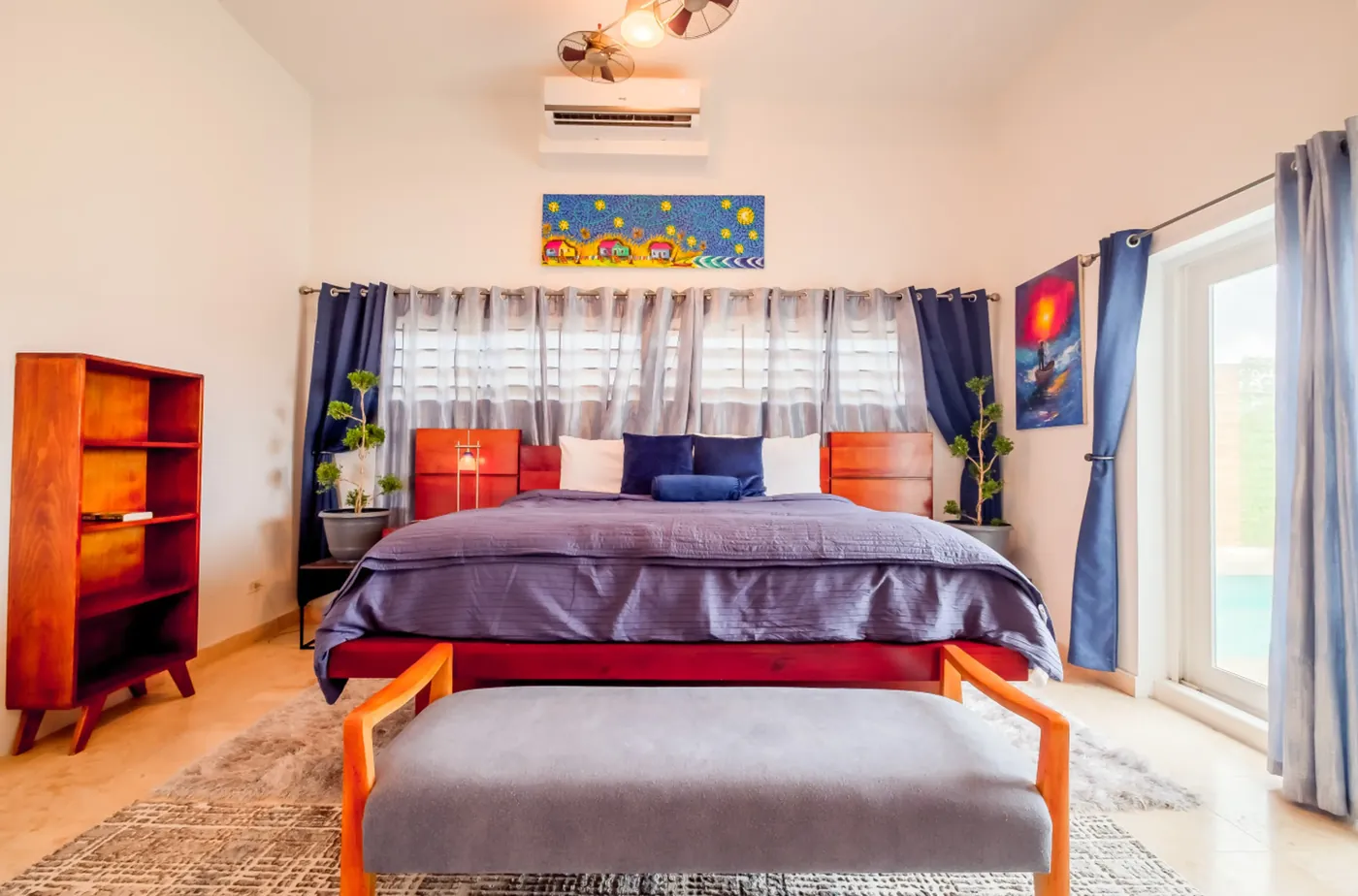 Master bedroom at Fox Villa Belize with a king bed, colorful local artwork and pool views