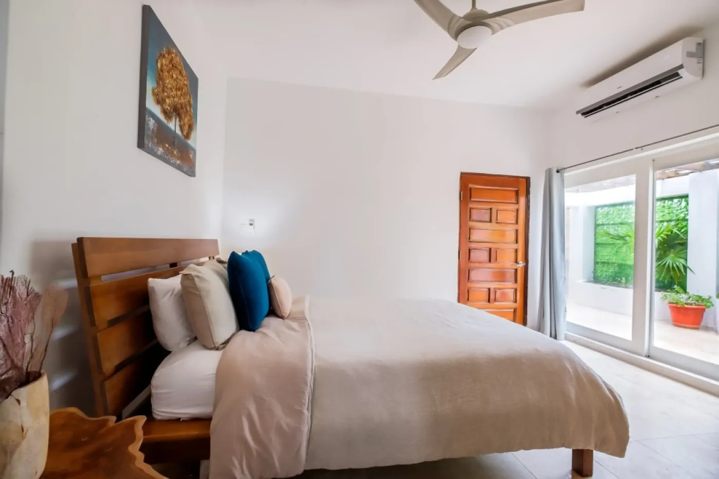 Bright guest bedroom at Fox Villa Belize opening onto a private garden patio