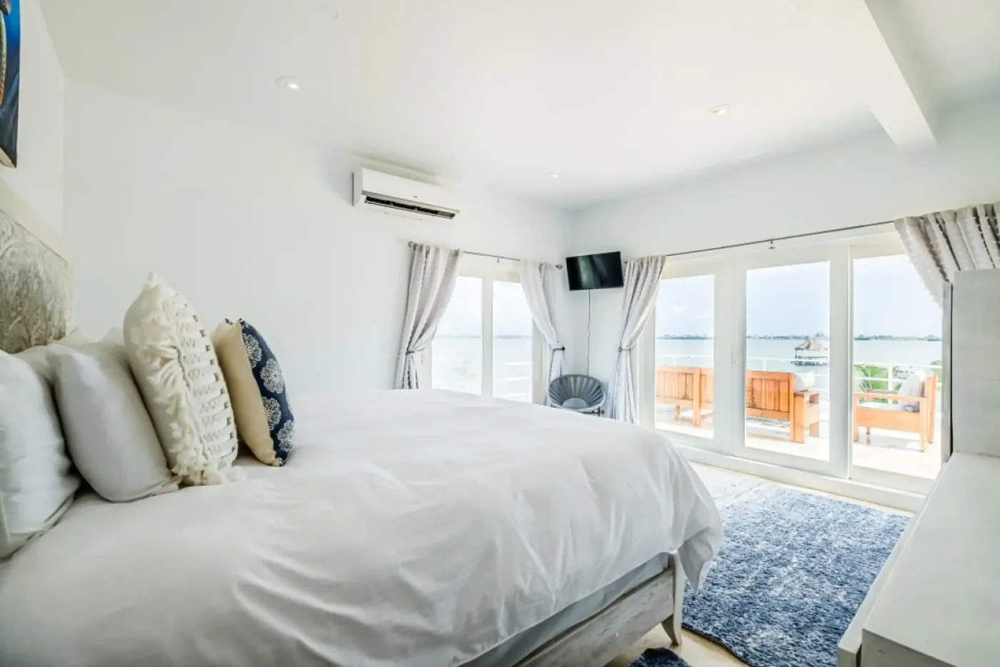 Ocean-view bedroom at Fox Villa Belize with floor-to-ceiling windows and terrace access