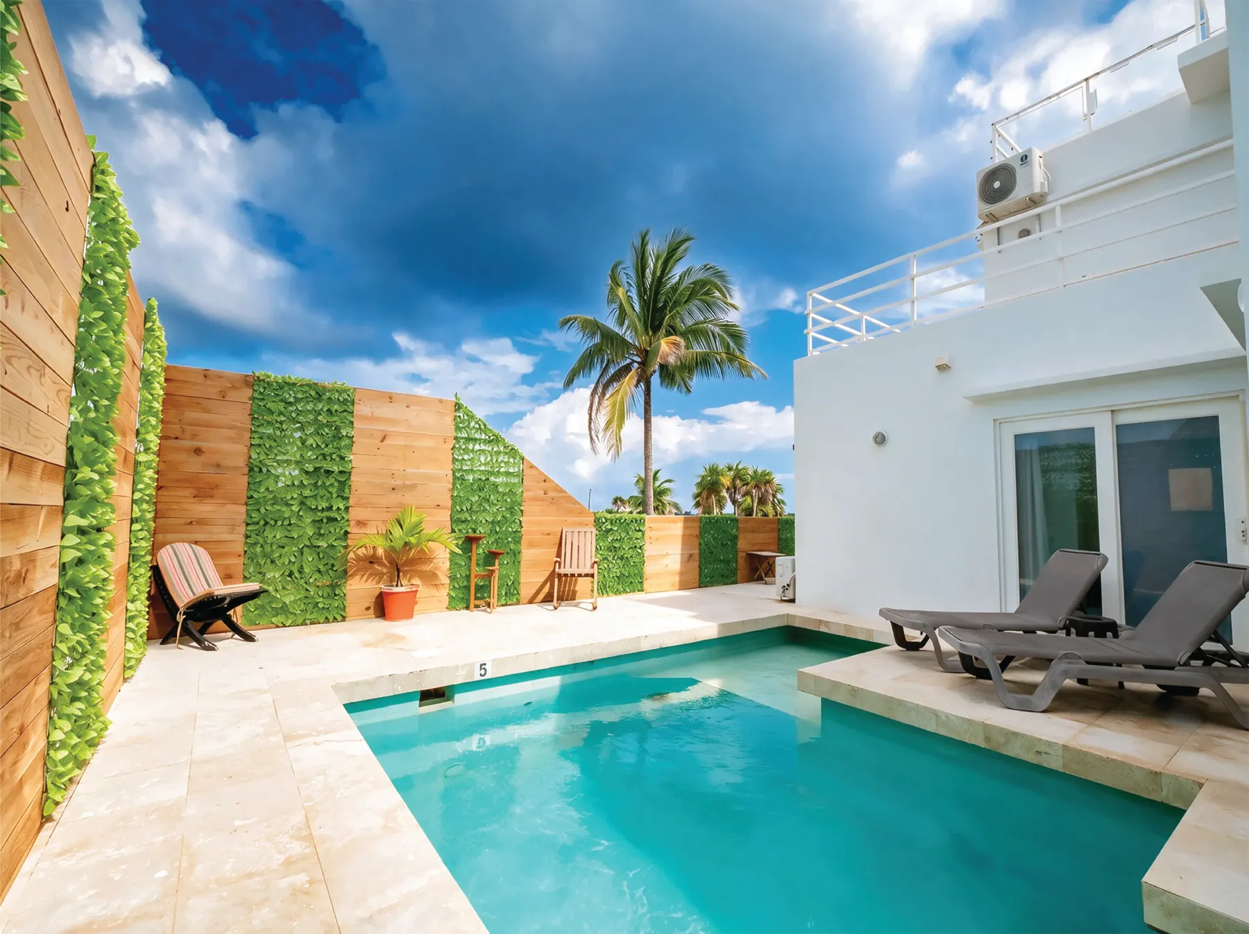 Secluded back pool with sun loungers and palms